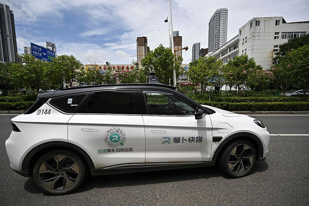 Close-up of a Baidu Apollo Go robotaxi, showing the side of the autonomous vehicle on a road