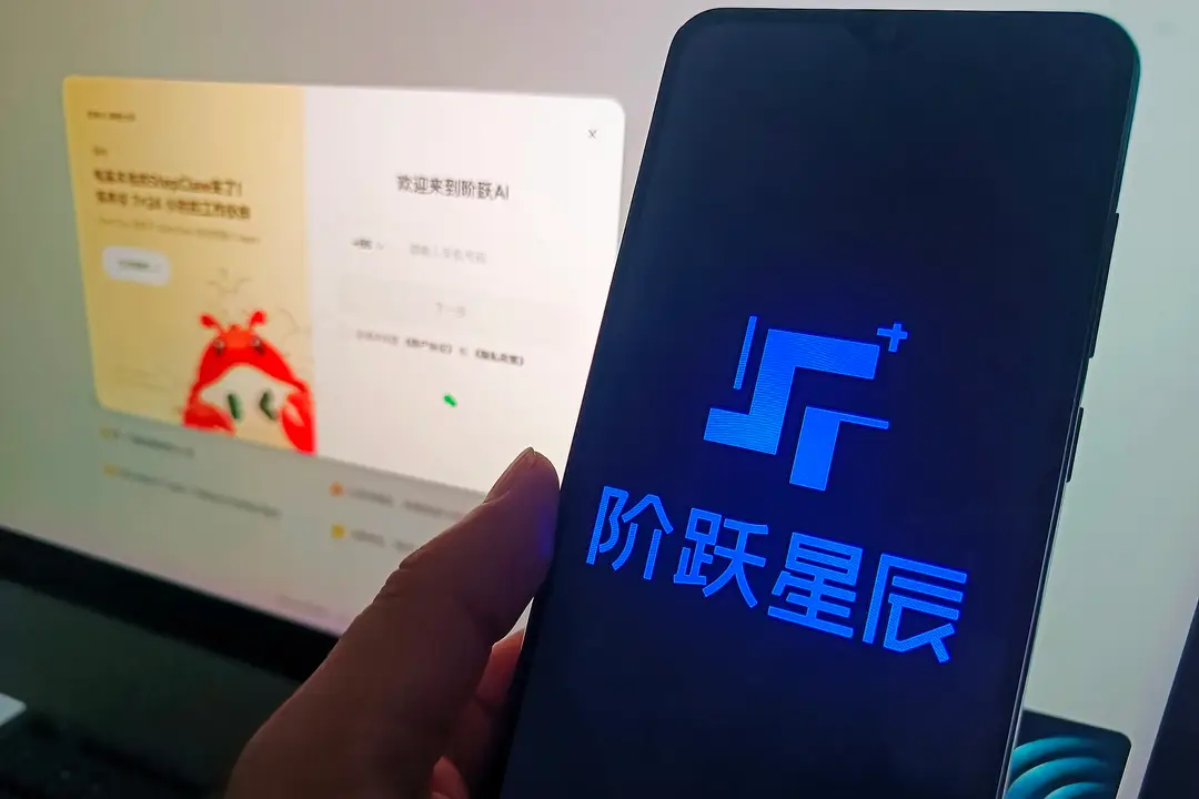 a mobile phone screen displays the StepFun logo with a computer screen's login interface as the background.
