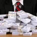 photograph shows wads of cash with a suited man in the background