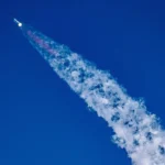 photograph shows a rocket flying across the sky with a trail of white smoke