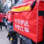 Photograph shows JD Instant Delivery vans and couriers at a distribution hub