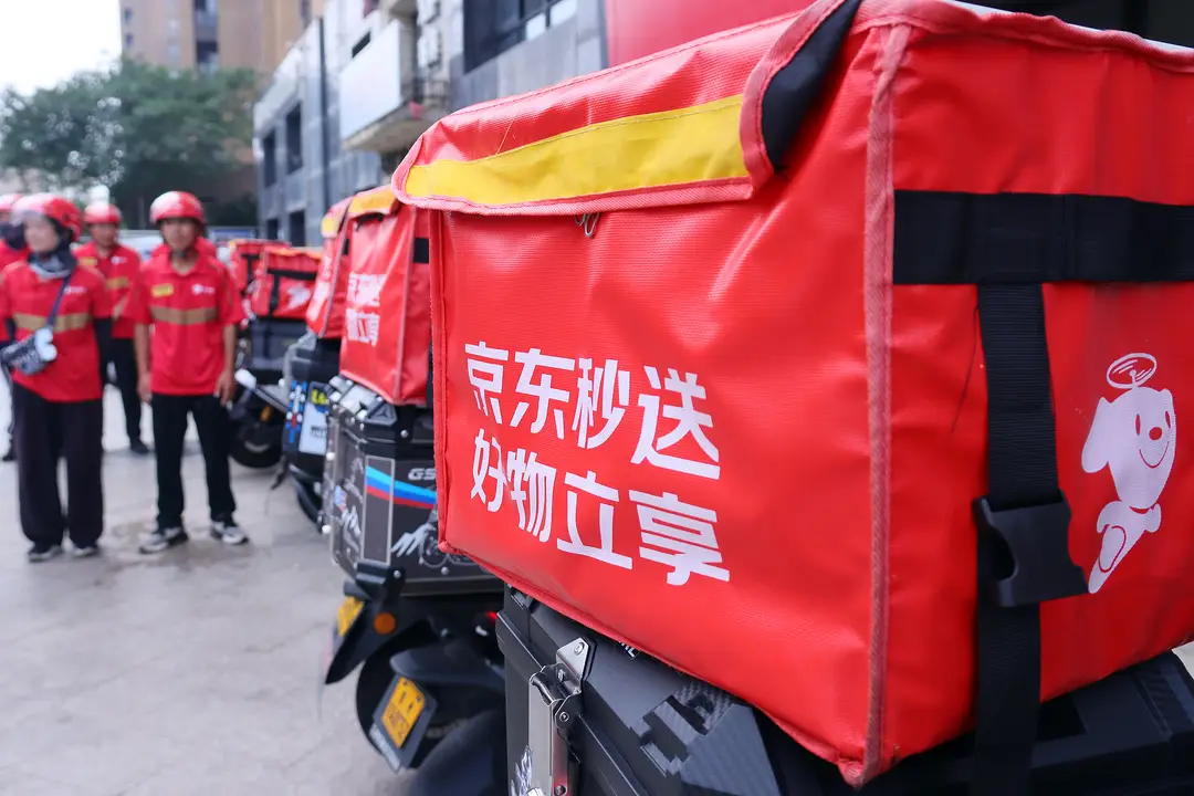 Photograph shows JD Instant Delivery vans and couriers at a distribution hub
