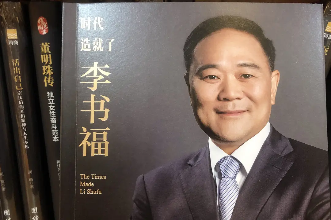 Photograph shows a picture of Li Shufu on the cover of his biography