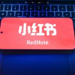 In this photo illustration, a RedNote logo displayed on a smartphone on the top of a laptop.