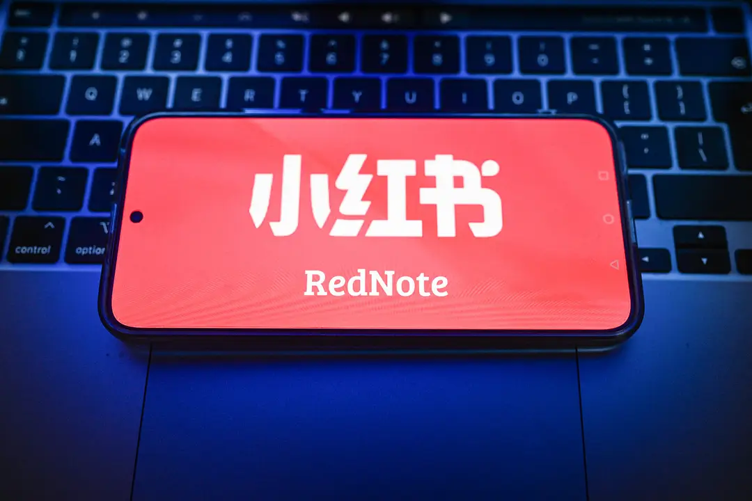 In this photo illustration, a RedNote logo displayed on a smartphone on the top of a laptop.
