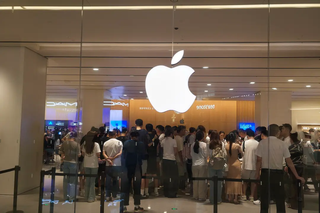 photograph shows customers queueing at the Apple Store in Shenzhen